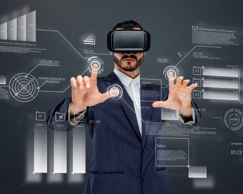 Male in a suit with virtual reality glasses on his head working in virtual financial world.